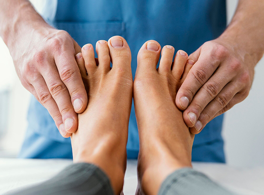 Exploración manual de los pies durante una consulta